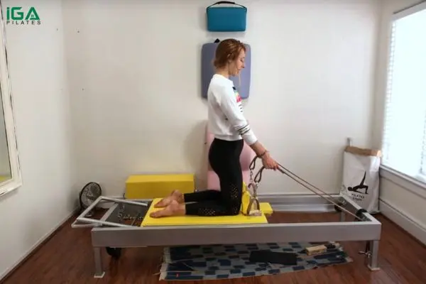 Bài tập Pilates Thigh Stretch trên Reformer: Cách thực hiện và lợi ích 6 Quỳ trên carriage (phần xe trượt) của Reformer