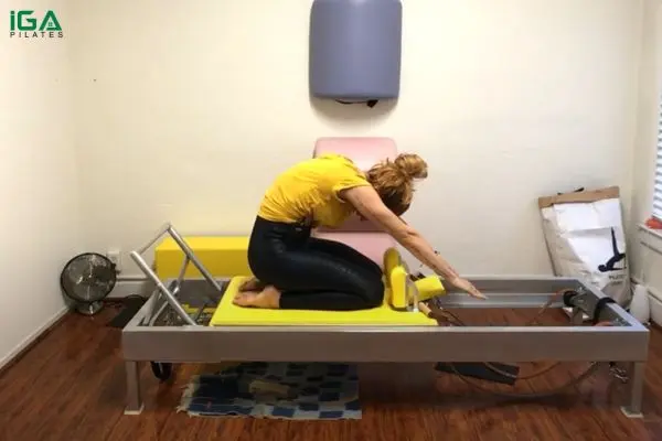 Bài tập Pilates Thigh Stretch trên Reformer: Cách thực hiện và lợi ích 9 Vươn tay qua đầu để kéo giãn toàn thân